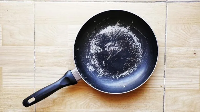 A scratched black non-stick frying pan