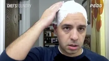 A man puts shaving foam on his head